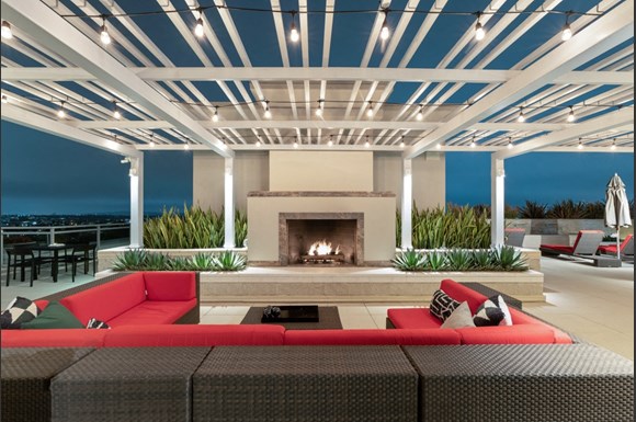 Westwood Luxury Apartments Wilshire Victoria  Rooftop Resident Lounge Couch Fireplace evening dusk4